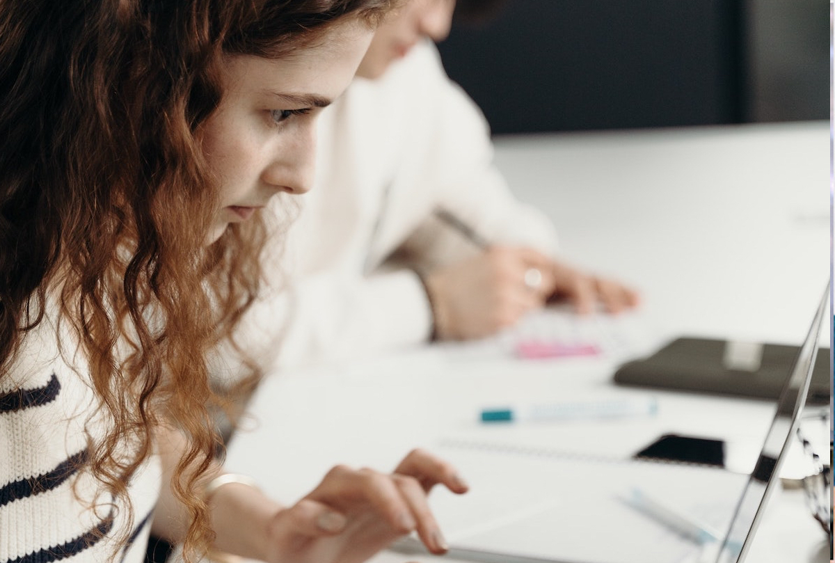 Fokusert elev jobber på laptop ved et skrivebord